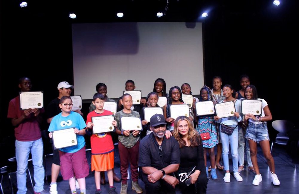 Tina's Angels and Richard's Warriors pose in a group and holding awards